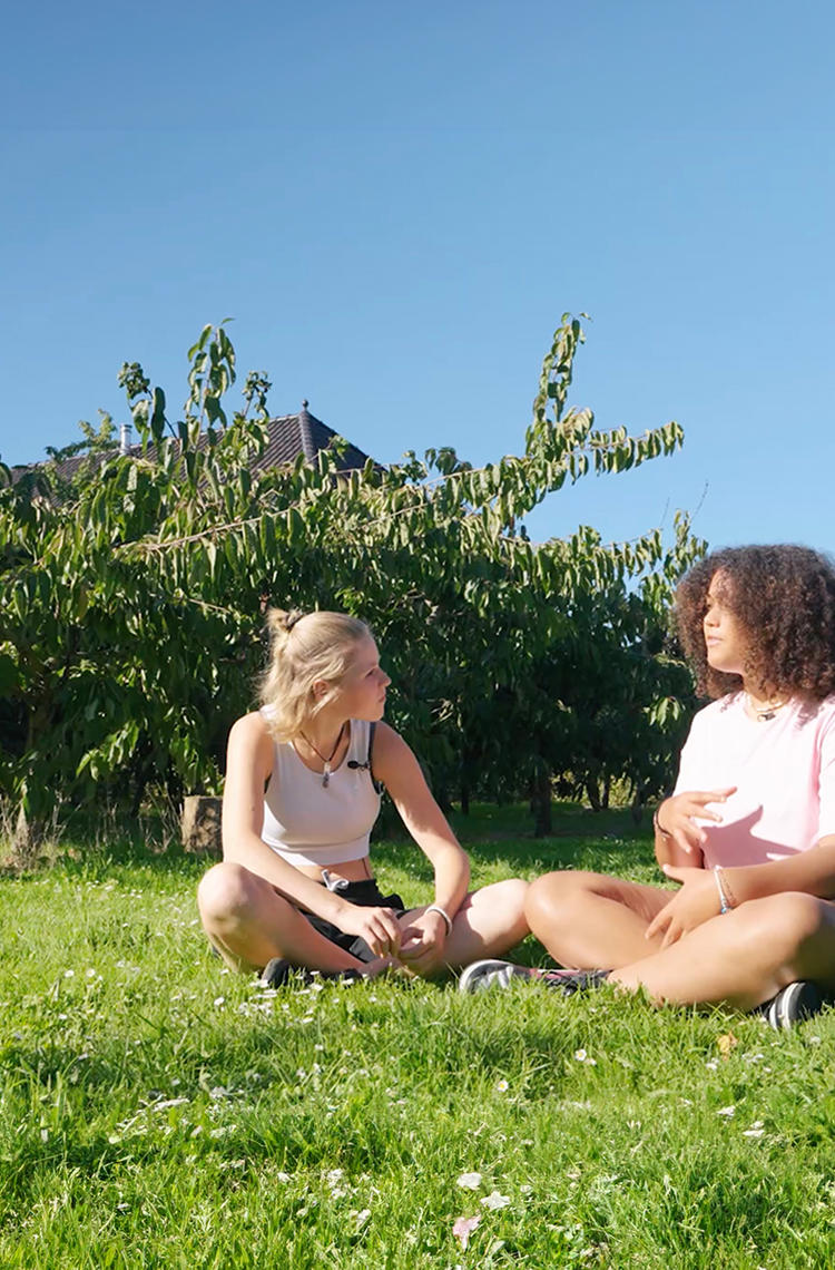 two young ladies discussing on the grass from Between Teenagers series two young ladies discussing on the grass from Between Teenagers series